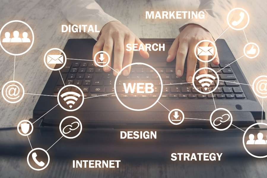 Vue en plongée de mains sur un clavier d'ordinateur portable entouré d'un réseau d'icônes lumineuses symbolisant le web décentralisé et la communication.